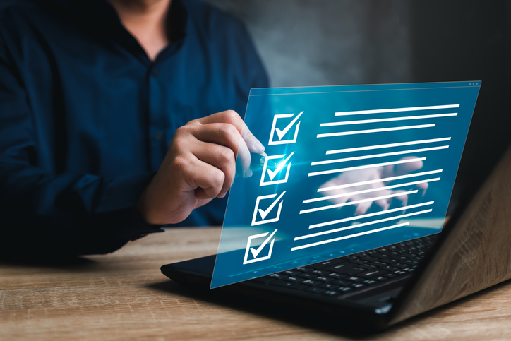 Person using a laptop interacting with a digital checklist displaying multiple checked items.
